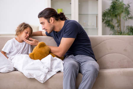 Father taking care of his ill daughterの写真素材