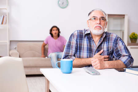 Young student and his old grandpa at home