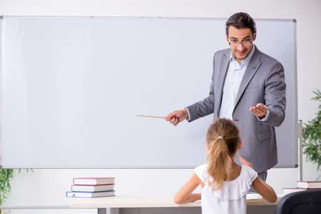 Teacher with young girl in the classroomの写真素材