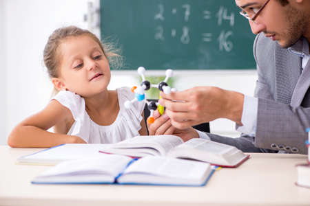 Teacher with young girl in the classroomの写真素材