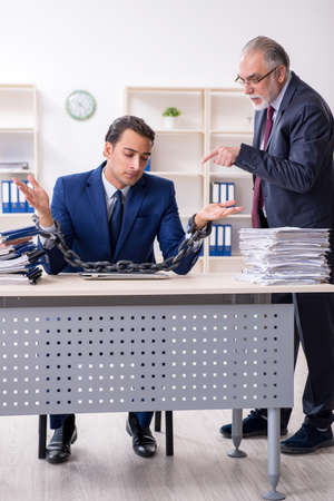 Old boss and young male employee in the officeの写真素材