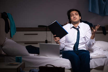 Young employee working at home after night shiftの写真素材