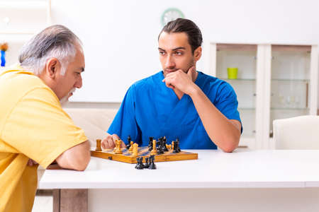 Young male doctor visiting old patient at homeの写真素材