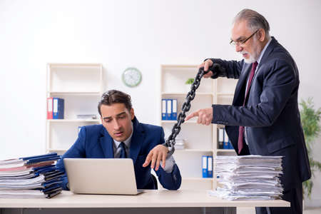 Old boss and young male employee in the officeの写真素材