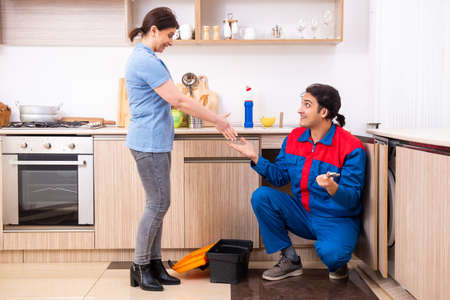 Young male repairman repairing tap