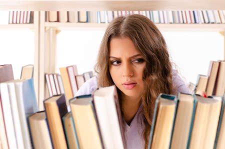 Young female student preparing for exams at library