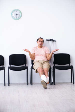 Young injured man waiting for his turn in hospital hallの写真素材