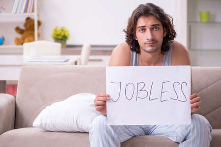 Unemployed man desperate at homeの写真素材