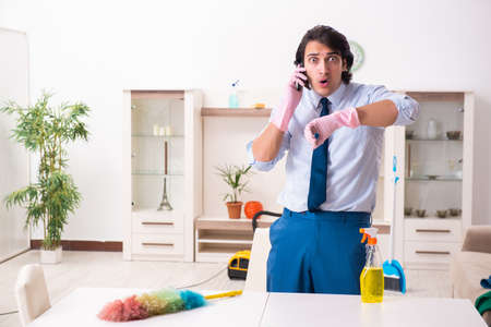 Young businessman cleaning the houseの写真素材