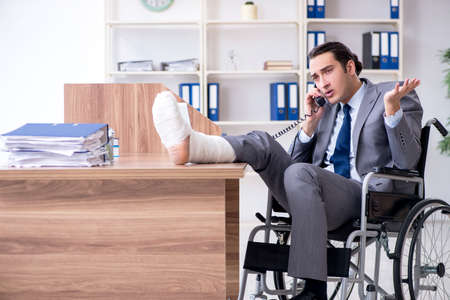 Male employee in wheel-chair in the officeの写真素材