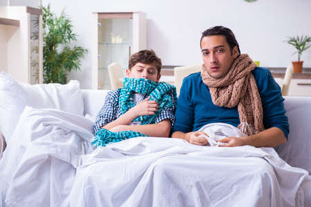 Young father caring for sick sonの写真素材