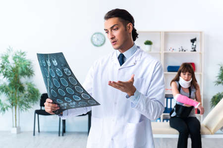 Young woman visiting male doctor traumatologistの写真素材