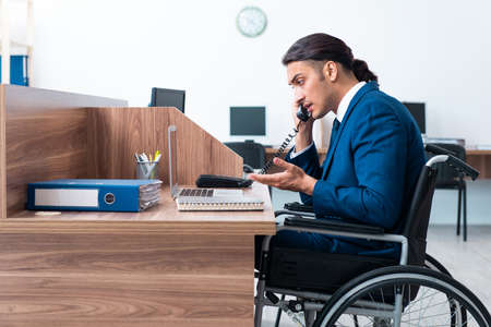 Young male employee in wheel-chairの写真素材