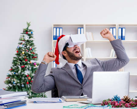 Young businessman celebrating christmas in the officeの写真素材
