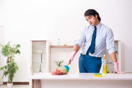 Young businessman cleaning the houseの写真素材