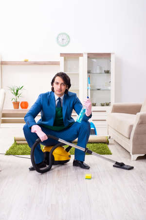 Young businessman cleaning the houseの写真素材