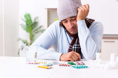 Young man suffering from flu at homeの写真素材