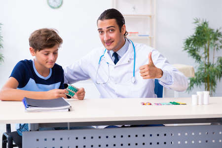 Young male doctor examining boy in the clinicの写真素材