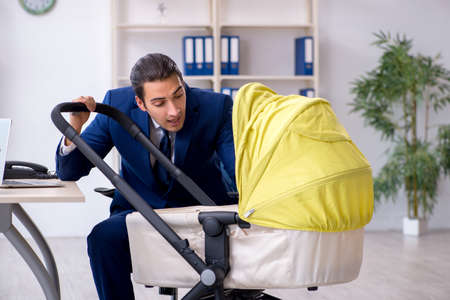 Young father looking after newborn in the officeの写真素材