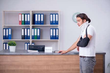 Young man at hospital reception deskの写真素材