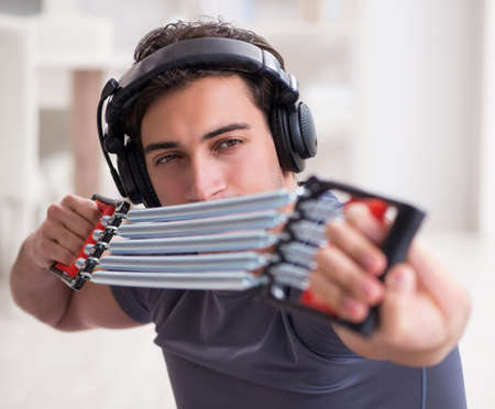 Man doing sports with resistance band and listening to music