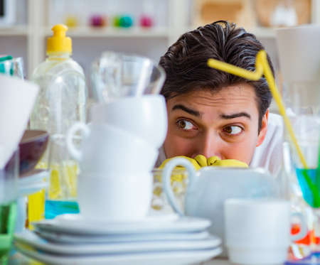Man frustrated at having to wash dishesの写真素材