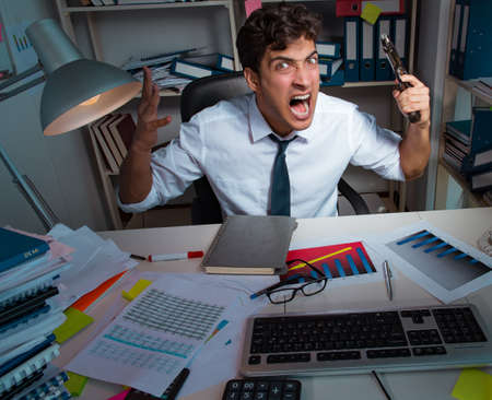 Man businessman working late hours in the officeの写真素材