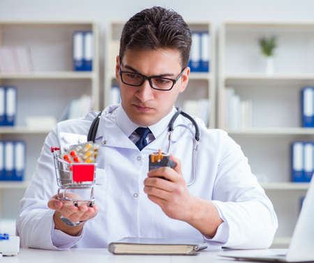 Male doctor in anti-smoking conceptwithcigarette packの写真素材
