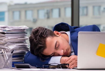 Workaholic businessman overworked with too much work in officeの写真素材