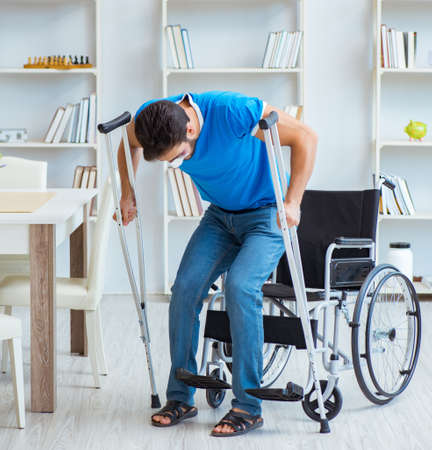 Young man recovering after surgery at home with crutches and a wの写真素材