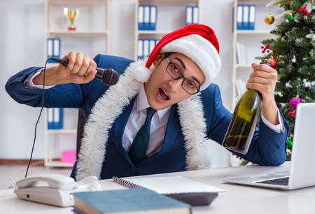 Businessman celebrating christmas holiday in the officeの写真素材