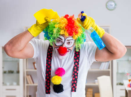 Funny clown doing cleaning at homeの写真素材