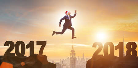 Businessman in santa hat jumping from 2017 to 2018の写真素材