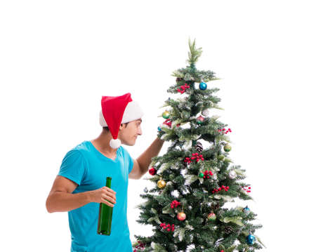 Young man decorating christmas tree isolated on whiteの写真素材