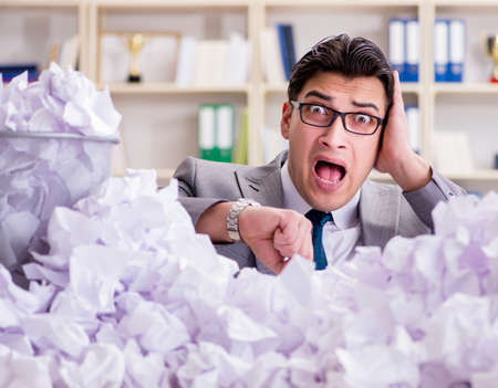 Businessman in paper recycling concept in officeの写真素材