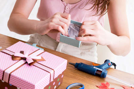 Woman decorating gift box for special occasionの写真素材