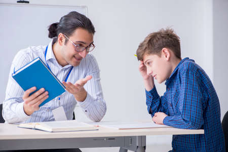 Young male teacher and boy in the classroom