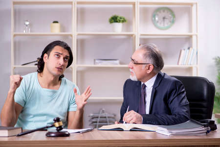 Young man visiting experienced male lawyerの写真素材