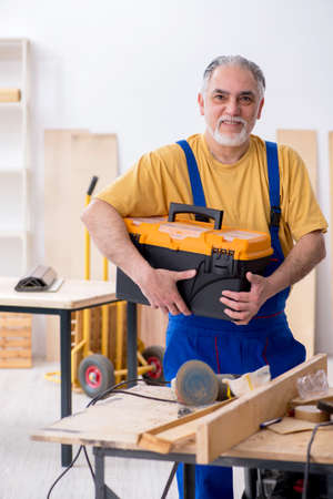 Old male carpenter working in workshopの写真素材