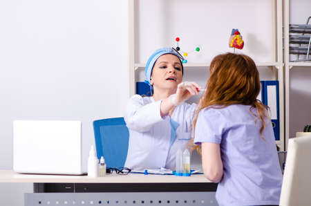 Young woman visiting female doctor otolaryngologistの写真素材