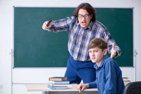 Boy using smartphone during the lesson