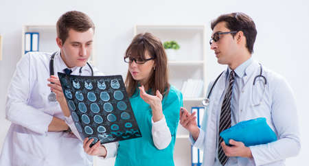Three doctors discussing scan results of x-ray image