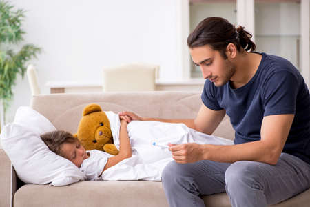 Father taking care of his ill daughterの写真素材