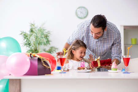 Father celebrating birthday with his daughterの写真素材