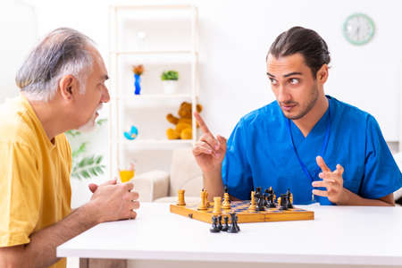 Young male doctor visiting old patient at homeの写真素材