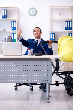 Young father looking after newborn in the officeの写真素材