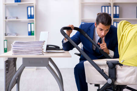 Young father looking after newborn in the officeの写真素材