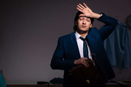 Young employee working at home after night shiftの写真素材