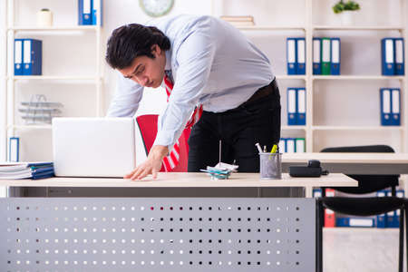 Young male employee suffering in the officeの写真素材