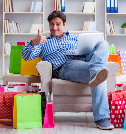Young man after excessive shopping at homeの写真素材